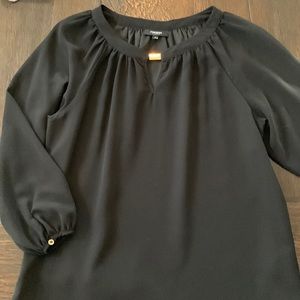 Black blouse with statement neckline embellishment.